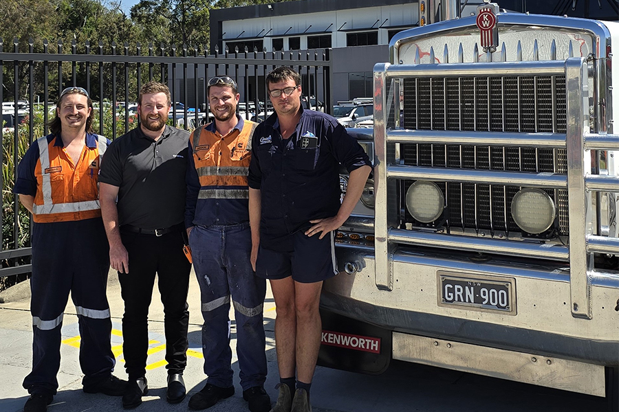 Employees smiling in front of truck