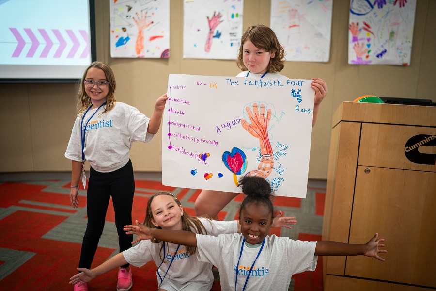 Students standing with their artwork