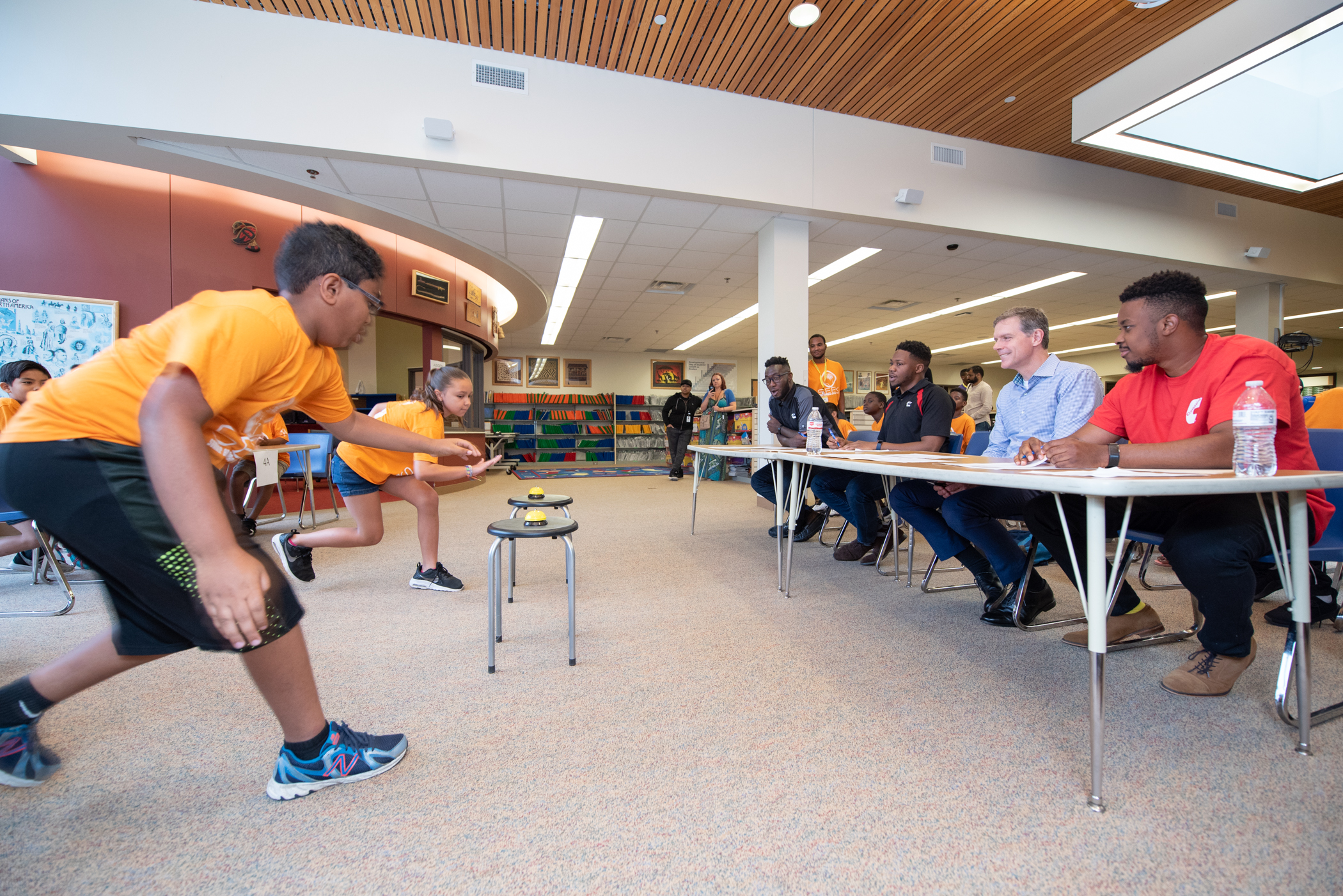 Fourth grade SEEK participants race to answer an engineering trivia question, as judges from the Shoreview and Fridley facilities look on.