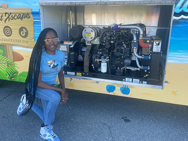 Mclaurin sitting next to Onan SD20 generator placed inside the mobile business